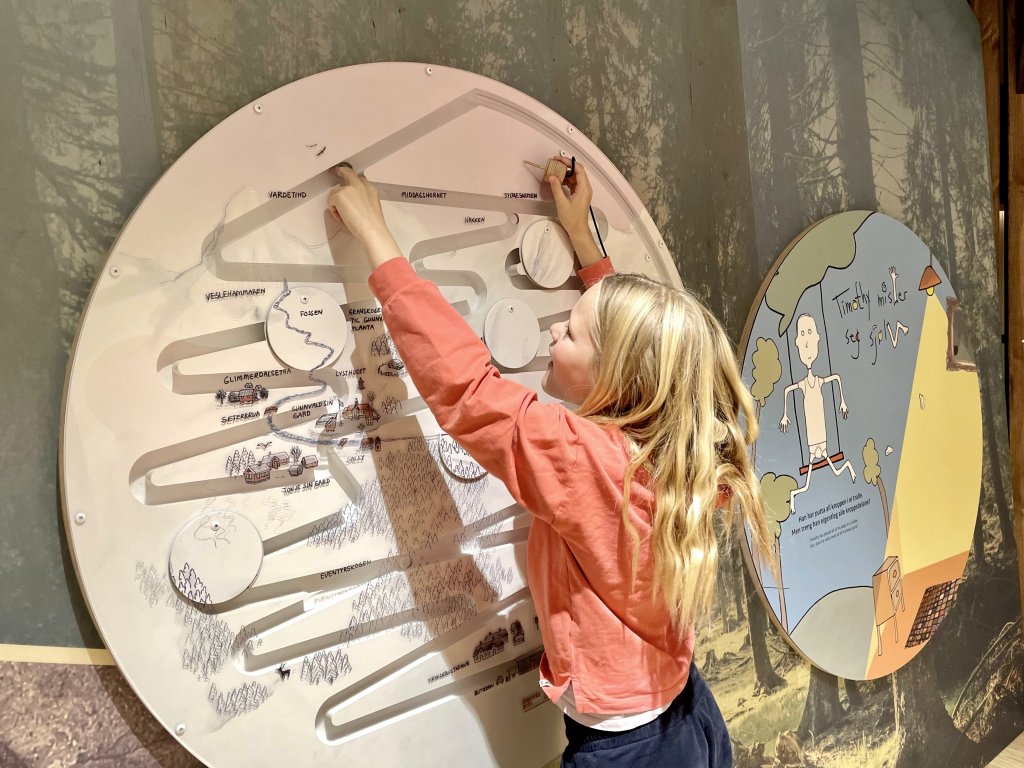 Bilete av jente som leikar med ein Tonje Glimmerdal-installasjon i utstillinga ved Vinjesenteret.